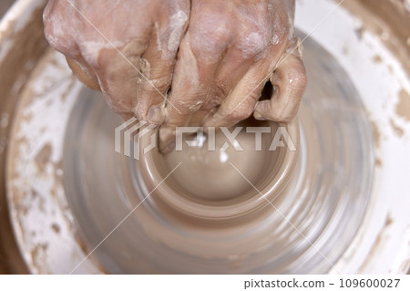 male hands making ceramic cup on pottery wheel, Close-up, top view male hands making ceramic cup on pottery wheel, Close-up, top view 109600027