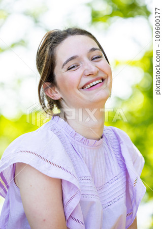 Joyful Radiance: A Woman's Beaming Smile in Sunlit Surroundings 109600177