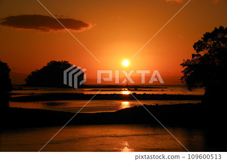 The sight of the sun rising between small islands floating in the Ariake Sea 109600513
