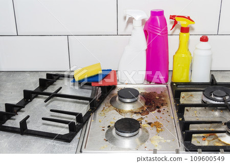Dirty, top of the gas stove with bits of food. House cleaning. 109600549