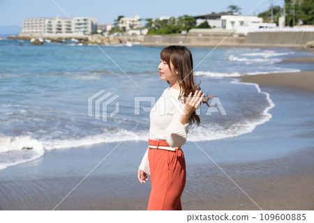A woman standing on a sandy beach A woman standing on a sandy beach 109600885