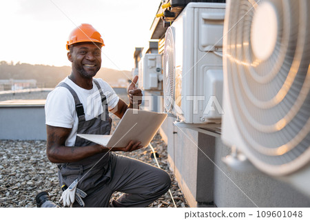 Man repairing device for cooling with laptop in hands Man repairing device for cooling with laptop in hands 109601048