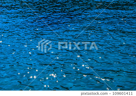 Blue sea in sunshine glow as surface background. Summer holidays and coastal nature concept 109601411