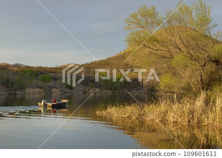 Fishing boat heading out at sunset, Patagonia Lake State Park, Arizona, USA 109601611