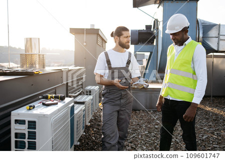 Diverse craftsmen standing and discussing issues outdoor Diverse craftsmen standing and discussing issues outdoor 109601747