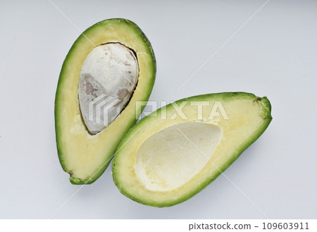 Avocado fruit cut in half on a white background. Green fruits are for vegetarians. Delicious diet food. Avocado fruit cut in half on a white background. Green fruits are for vegetarians. Delicious diet food. 109603911