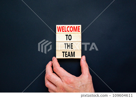 Welcome to the team symbol. Concept words Welcome to the team on wooden block. Beautiful black table black background. Businessman hand. Business, motivational and welcome to the team concept. 109604611