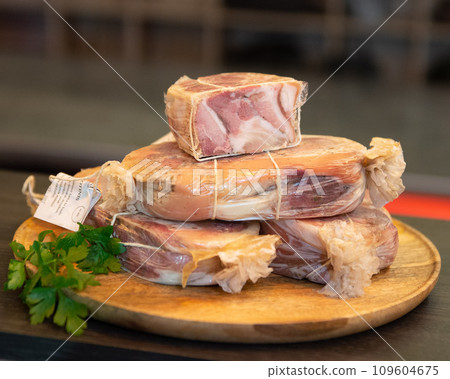 Smoked sliced pork belly, bacon, ham with herbs, tomatoes and black pepper on food paper. Wooden rustic background.Selective focus.Horizontal view. 109604675