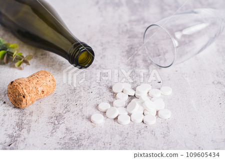 Sobriety concept, alcoholism pills, bottle and glass on the table Sobriety concept, alcoholism pills, bottle and glass on the table 109605434