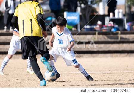 Elementary school boy playing soccer match 109607431