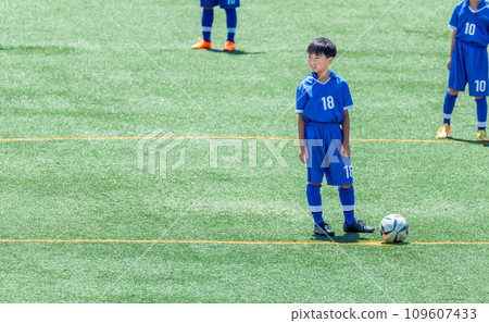 Elementary school boy playing soccer match Elementary school boy playing soccer match 109607433