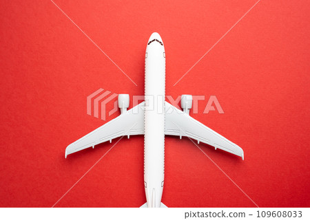 Airline plane top view on red background. Passenger transportation. Business and tourism. Airline. World communication and commercial flights. Arrival and departure. 109608033