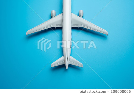 Airline plane top view on blue background. Passenger transportation. Business and tourism. Airline. World communication and commercial flights. Place for text. Arrival and departure. Airplane arrival. Airline plane top view on blue background. Passenger transportation. Business and tourism. Airline. World communication and commercial flights. Place for text. Arrival and departure. Airplane arrival. 109608066
