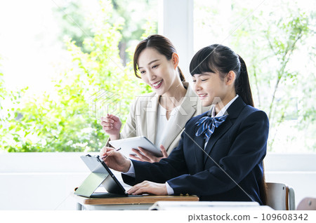 Junior high school girls and female teachers studying on tablet PCs Junior high school girls and female teachers studying on tablet PCs 109608342
