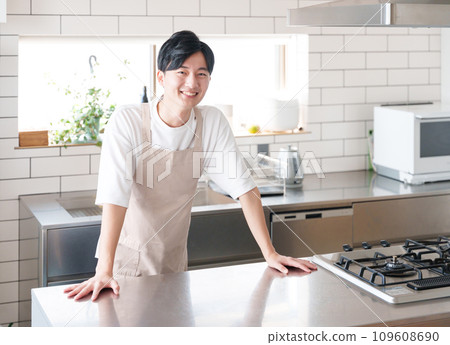 Smiling man cooking in the kitchen Smiling man cooking in the kitchen 109608690