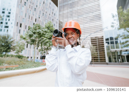 Black female architect taking photo on camera 109610141