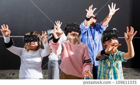 Excited tweens in VR glasses playing virtual reality games Excited tweens in VR glasses playing virtual reality games 109611335