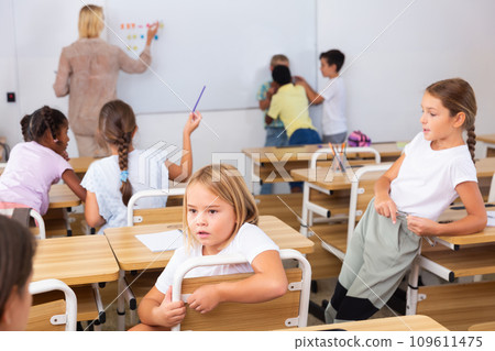 Tween boys and girls friendly talking in break in classroom Tween boys and girls friendly talking in break in classroom 109611475
