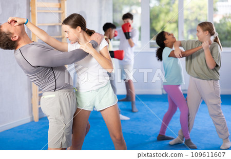 Tween girl attacking eyes of coach during sparring at self-defense training 109611607