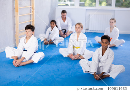 Group of children practicing butterfly pose in studio 109611683