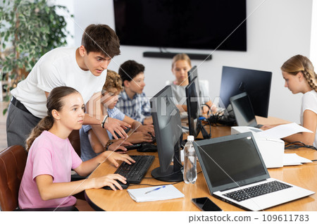 Guy teacher teaches girl student how to use computer Guy teacher teaches girl student how to use computer 109611783
