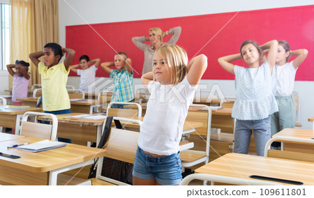 Kids pupils having physical training between lessons Kids pupils having physical training between lessons 109611801