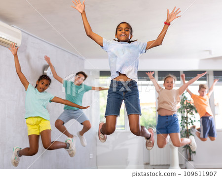 African boy engaged shake leg in fitness hall with friend, group of youthful people jumped into air African boy engaged shake leg in fitness hall with friend, group of youthful people jumped into air 109611907