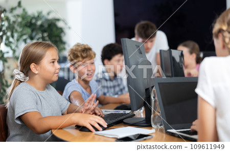Computer science lesson in a school computer class - a girl and a boy solve problems on computer together 109611949