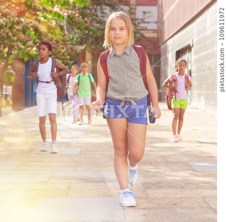 Portrait of little girl walking at schoolyard Portrait of little girl walking at schoolyard 109611972