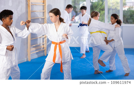 Boy and girl training karate techniques in studio 109611974
