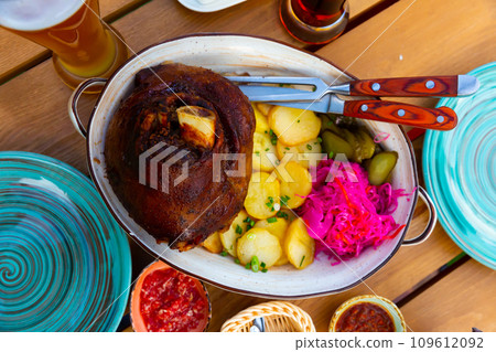 Roasted pork knuckle with potato and pickles Roasted pork knuckle with potato and pickles 109612092