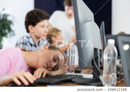 Girl student sleeps while sitting at computer Girl student sleeps while sitting at computer 109612106