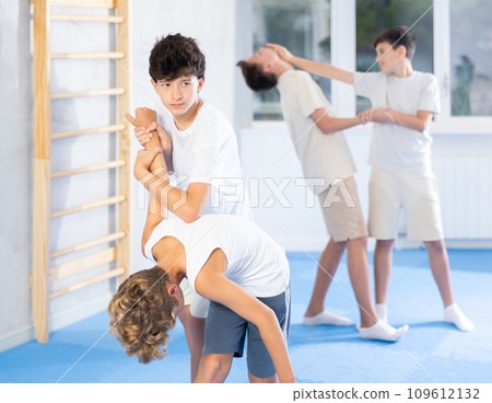 Teenagers practicing armlock in training sparring at self-defense classes Teenagers practicing armlock in training sparring at self-defense classes 109612132