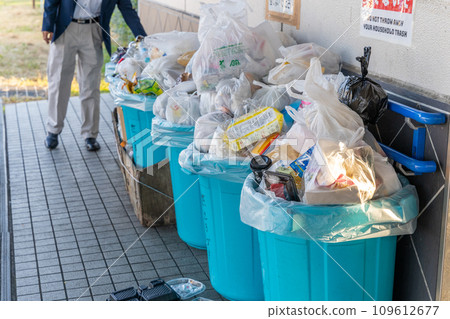 Overflowing garbage collection site, man throwing away garbage Overflowing garbage collection site, man throwing away garbage 109612677