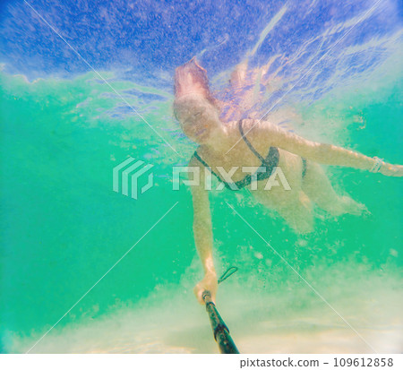In an ethereal underwater scene, a pregnant woman gracefully floats, embodying the beauty of maternity beneath the tranquil surface of the sea 109612858