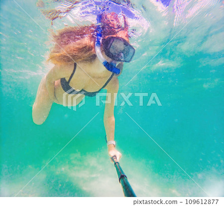 In an ethereal underwater scene, a pregnant woman gracefully floats, embodying the beauty of maternity beneath the tranquil surface of the sea 109612877
