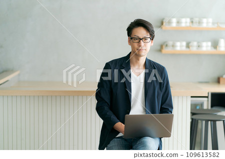 A man who uses a personal computer at a cafe 109613582