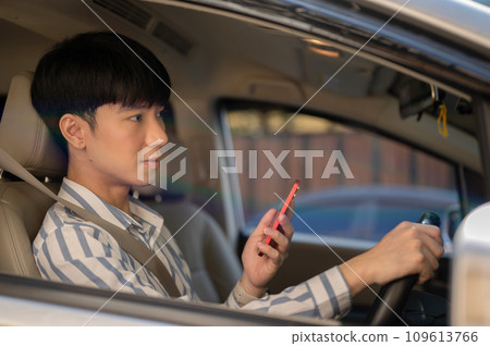 A man using his smartphone while driving a car. A man using map on his phone while driving. 109613766