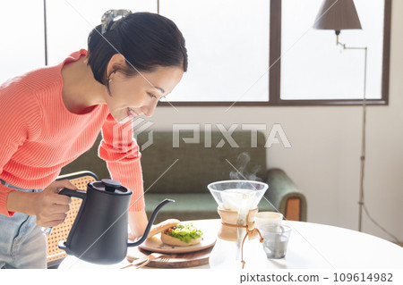 A woman who is making coffee A woman who is making coffee 109614982