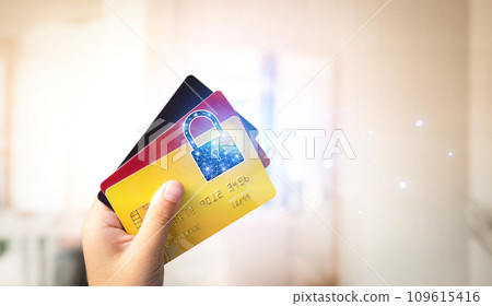 Close up of hand holding credit or debit card with padlock, protection of financial transactions Close up of hand holding credit or debit card with padlock, protection of financial transactions 109615416