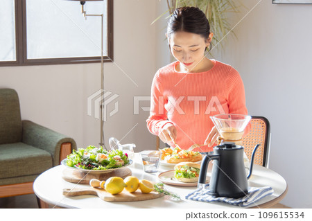 A woman eating a leisurely meal on holiday 109615534