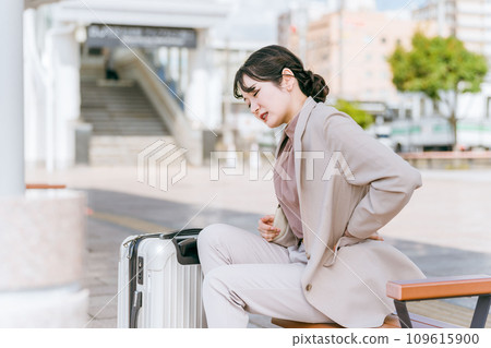 A business woman who felt unwell and had back pain while traveling at the station A business woman who felt unwell and had back pain while traveling at the station 109615900