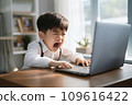 Gaming boy in white shirt appears frustrated or angry at a laptop screen, possibly due to a game challenging or computer issue 109616422
