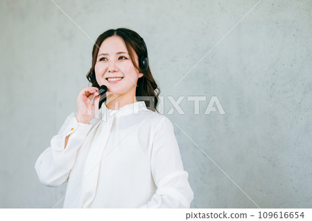 A woman wearing a headset for call center, operator, teleoperation, teleappointment, user support A woman wearing a headset for call center, operator, teleoperation, teleappointment, user support 109616654