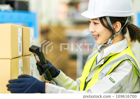 Young female worker scanning barcode in warehouse 109616700