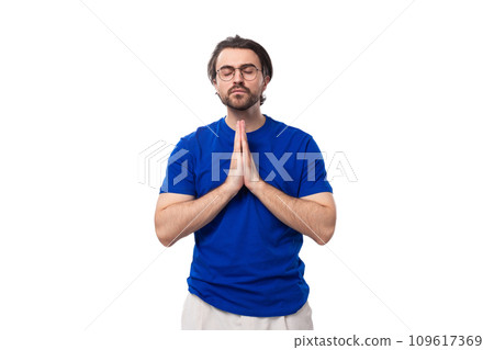 young concentrated european brunette man with a beard in glasses dressed in a blue t-shirt hopes 109617369