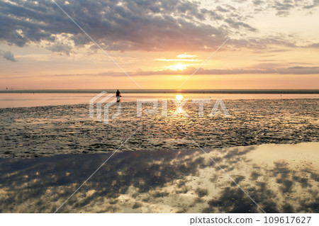 Wattenmeer, mud tideland in North Sea, Germany. Nordsee, Watt by sunset. Wattenmeer, mud tideland in North Sea, Germany. Nordsee, Watt by sunset. 109617627