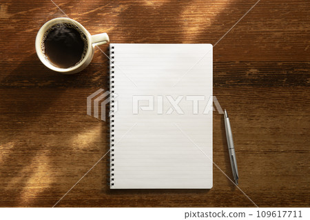 古董桌上放著筆記本、筆和咖啡。 古董桌上放著筆記本、筆和咖啡。 109617711