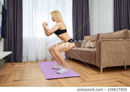 Middle aged woman during fitness workout at home 109617809