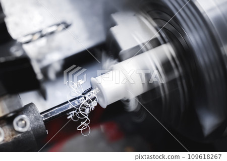 Operation of a CNC lathe on a workpiece made of textolite or polyethylene or propylene. Automation of the production base. The chips are flying. 109618267